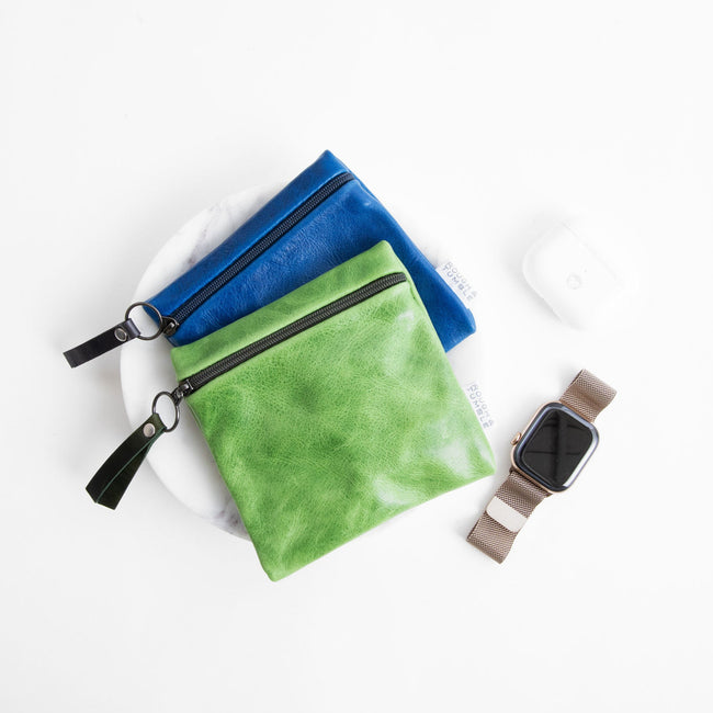 sweet pea + pine | card case in sweet pea, laying on top of a card case in baltic