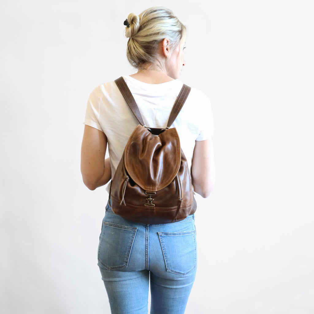 Back view of model wearing 1904 maxwell, size small, as a backpack. 
